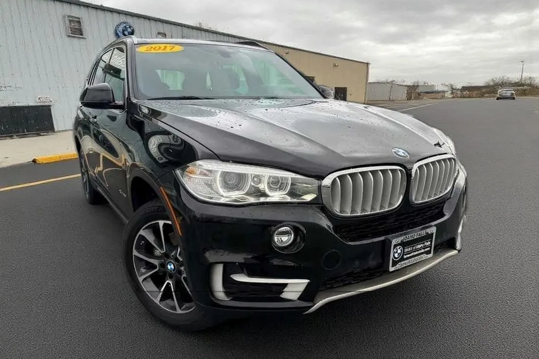 The same black BMW X5 with the banner and storefront replaced by a clean lot by AutoLander’s AI Photo Studio