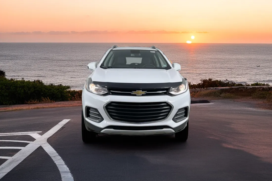 The same white Chevrolet Trax on a coastal overlook at sunset, staged by AutoLander’s AI Photo Studio