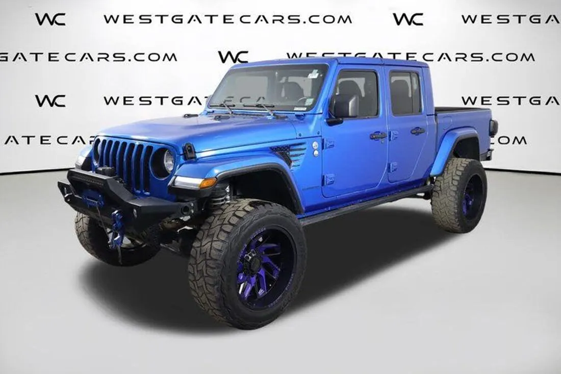 Blue Jeep Gladiator in a dealer photo with a watermarked backdrop, before AutoLander