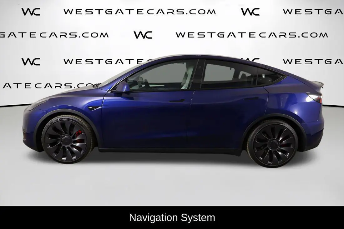 Tesla Model Y photographed in a busy dealer lot with distracting background, before editing