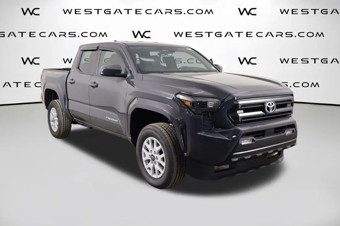 Toyota Tacoma pickup in a dark dealer lot photo, before AutoLander